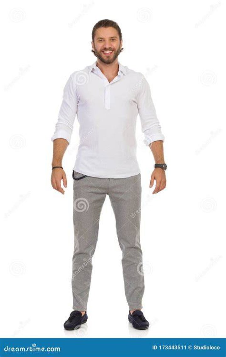 a man standing in front of a gym machine with his hands on his hips and