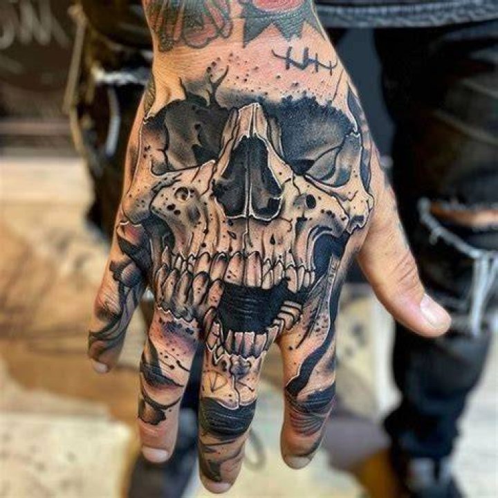 Skull tattoo on hand covering face Photograph by Johan Swanepoel